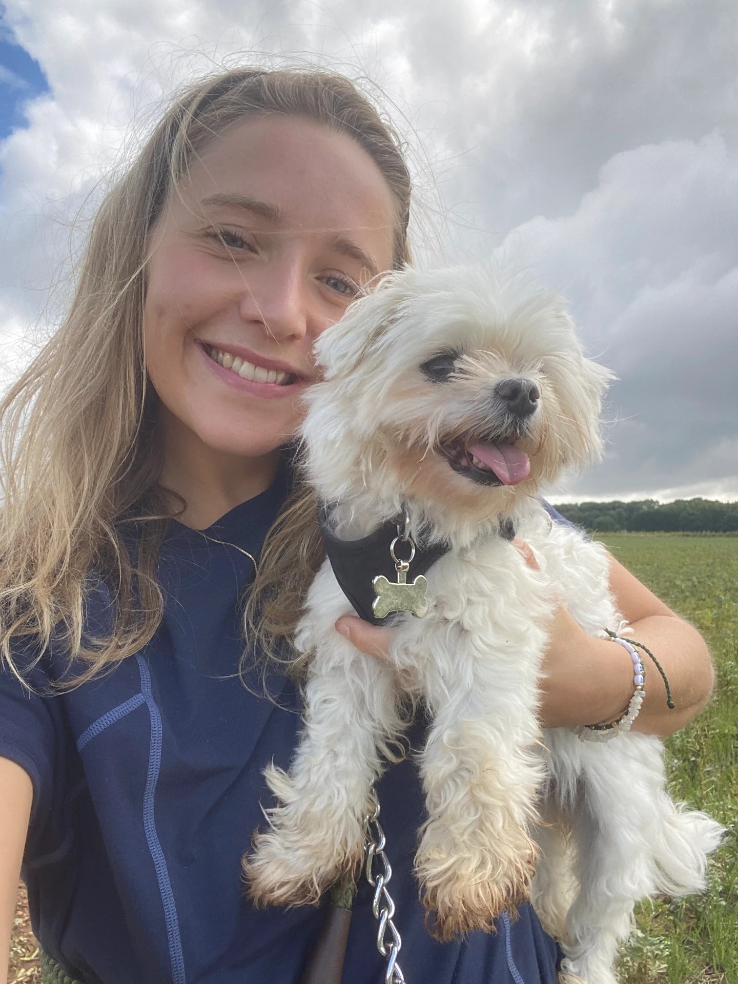 Daisy, founder of Daisy & Dogs, with a small white dog